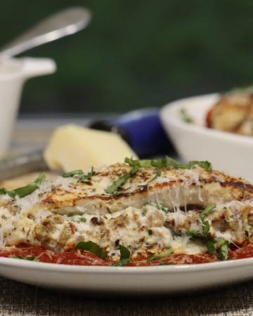 stuffed chicken breast oozing with sausage and cheese and topped with fresh parmesan and basil