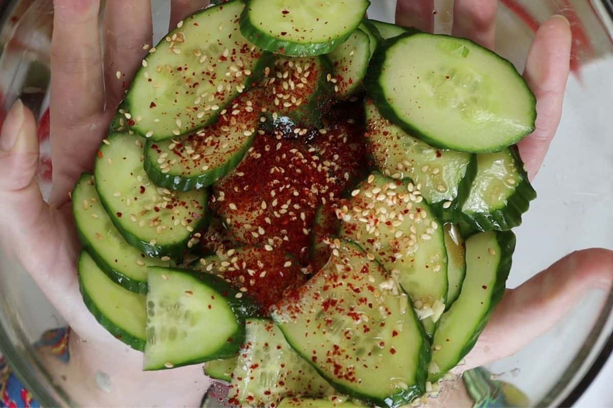 add the spicy korean cucumber ingredients to a bowl before tossing and eating