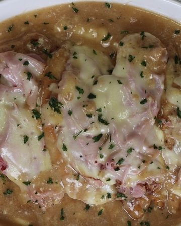 chicken valdostana on a platter with ham, cheese and sauce