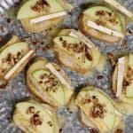 birds eye view of platter of apple brie crostini with pecans and honey drizzle