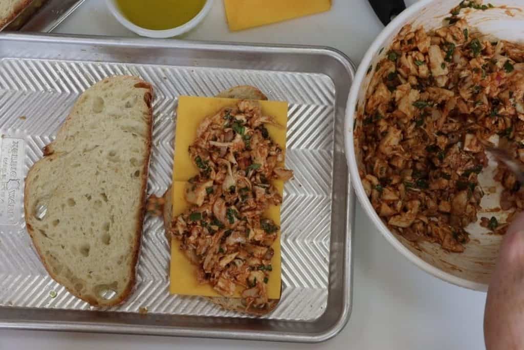 assembling the bbq chicken with cheddar and basil panini