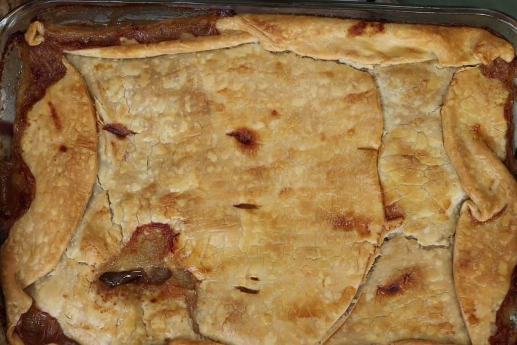 a close up look at the store bought crust version of Mrs Mann's steak & sausage pie right out of the oven