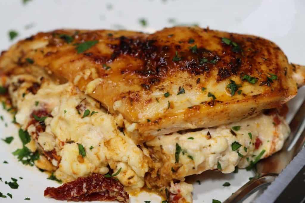 close up of one portions of stuffed chicken with sundried tomatoes and cheese