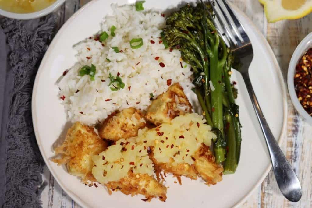 overview of a plate with coconut tofu, broccolini basmati rice red pepper flakes and scallions
