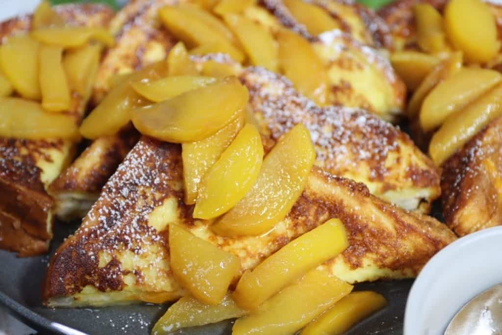 close up of a platter of cheddar stuffed french toast with peach compote