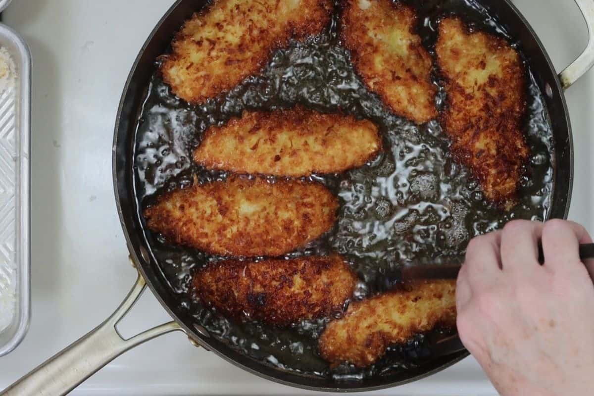 overhead view of frying the crunchy coconut chicken fingers