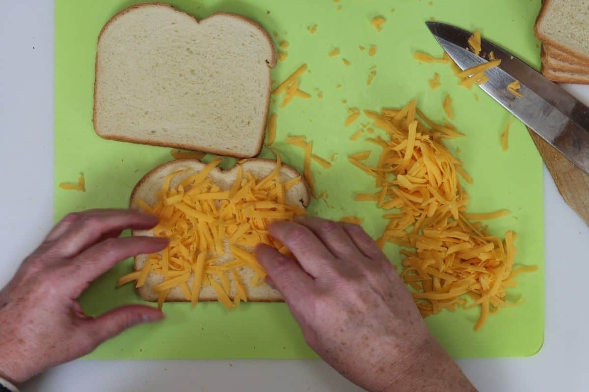 placing the mild orange cheddar cheese on the bread