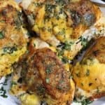 close up look of a platter with bone-in stuffed chicken breast with spinach and gouda garnished with parsley