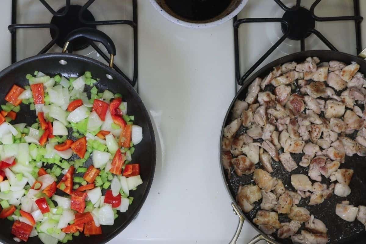 celery onion peppers in one pan and boneless chicken thighs in the other