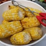 serving bowl filled with foil wrapped corn on the grill