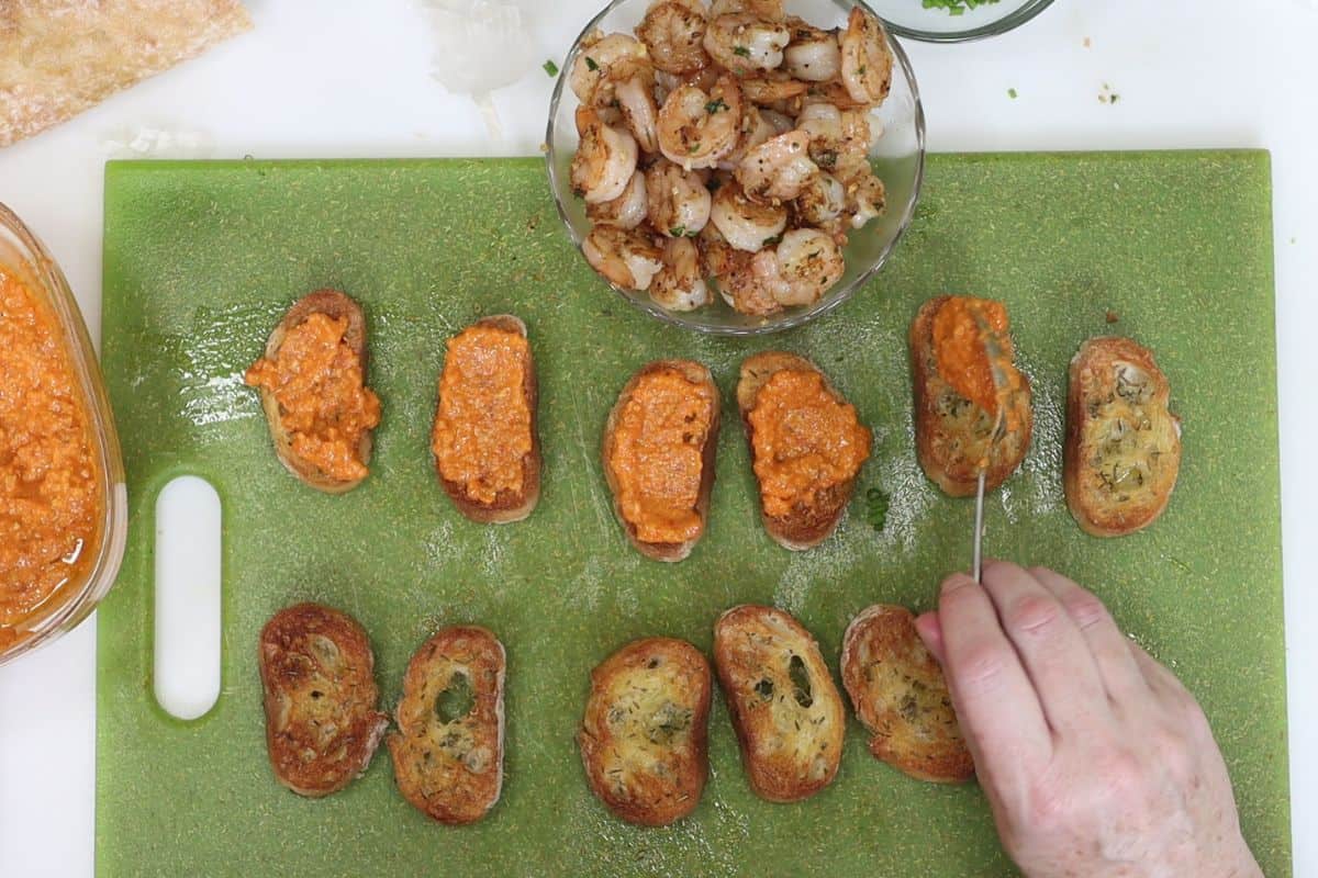 after you've broiled the crostini in your toaster oven, spoon the romesco onto each piece