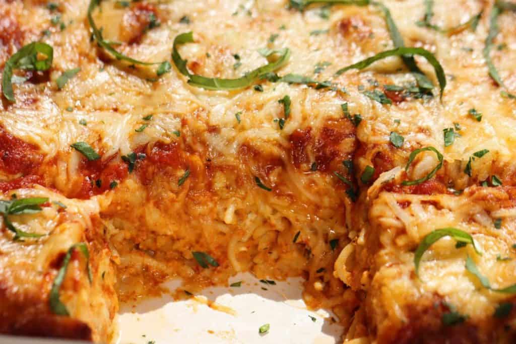 a look inside the ultimate spaghetti lasagna with ricotta, parmesan, mozzarella, basil, homemade sauce and sausage