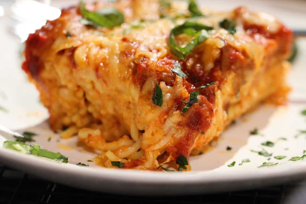 one portion of the ultimate spaghetti lasagna with ricotta, parmesan, mozzarella, basil, homemade sauce and sausage