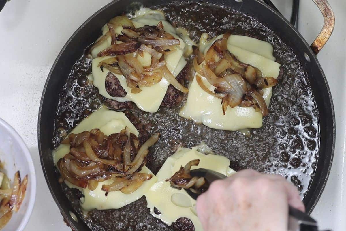 after the patties have cooked add slices of swiss cheese and sauteed onions