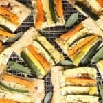 Roasted veggie tart with leeks and goat cheese cut into squares and ready to eat!