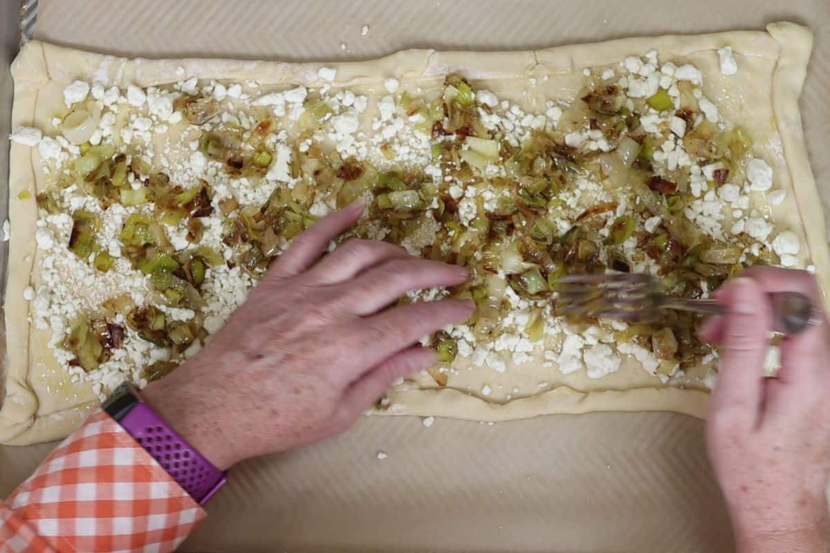 spread out your sauteed leeks on top of the crumbled goat cheese layer