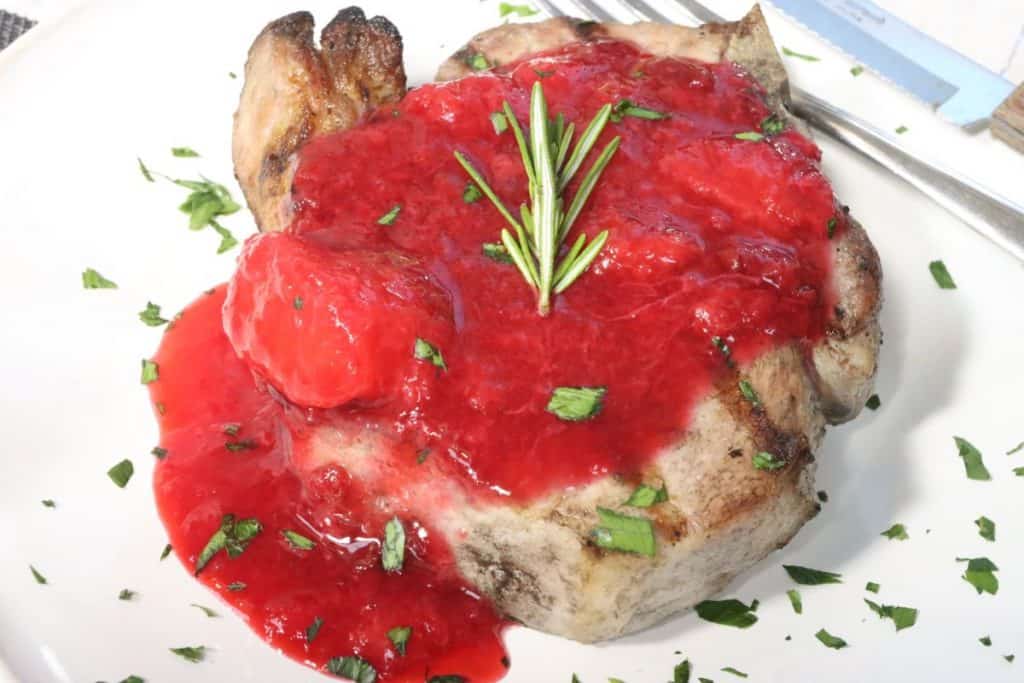 one bone-in center-cut pork chop grilled and topped with plum compote
