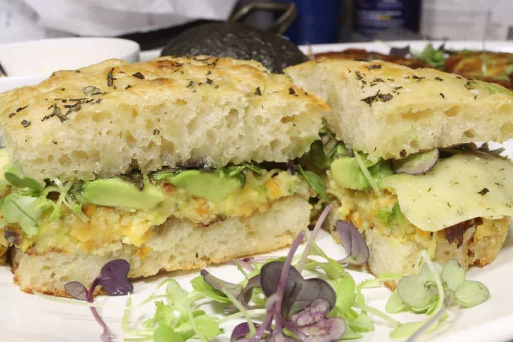 close up look of chickpea veggie burger on focaccia with dill havarti and honey mustard cut in half