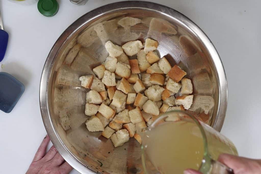 pour chicken broth over toasted bread crumbs and let it soak in