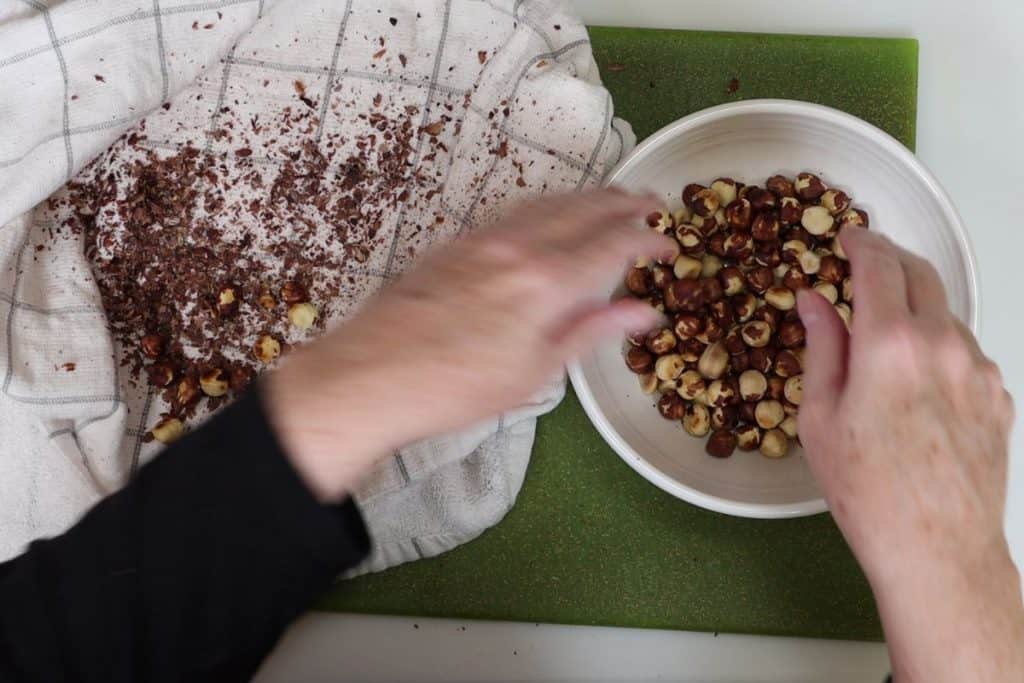 remove the warm hazelnuts from the towel and transfer to a bowl