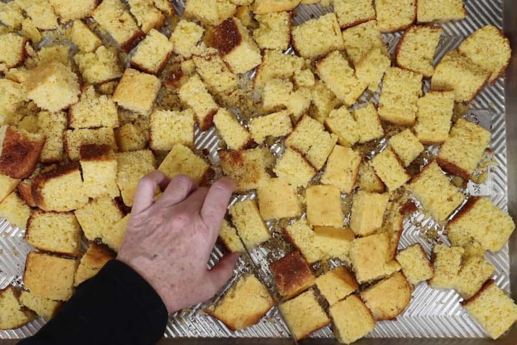 lay all the cornbread cubes on a large sheet pan and cut any cubes that are a little too big. Then you're ready to make in the oven until toasty