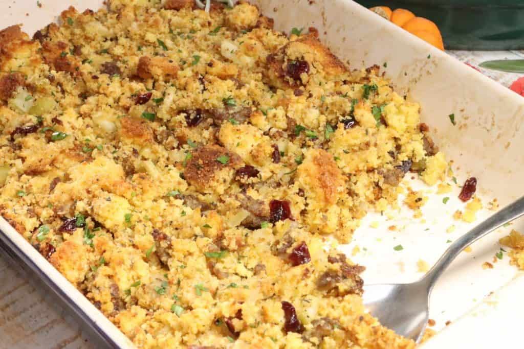 time to eat the bite. there is a scoop missing from this baking dish of sweet and savory cornbread stuffing with sausage. It is so delicious!