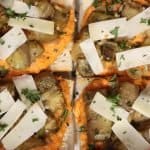overhead view of four pieces of french bread pizza with homemade romesco sauce, sauteed eggplant and shaved parmesan cheese served on a platter