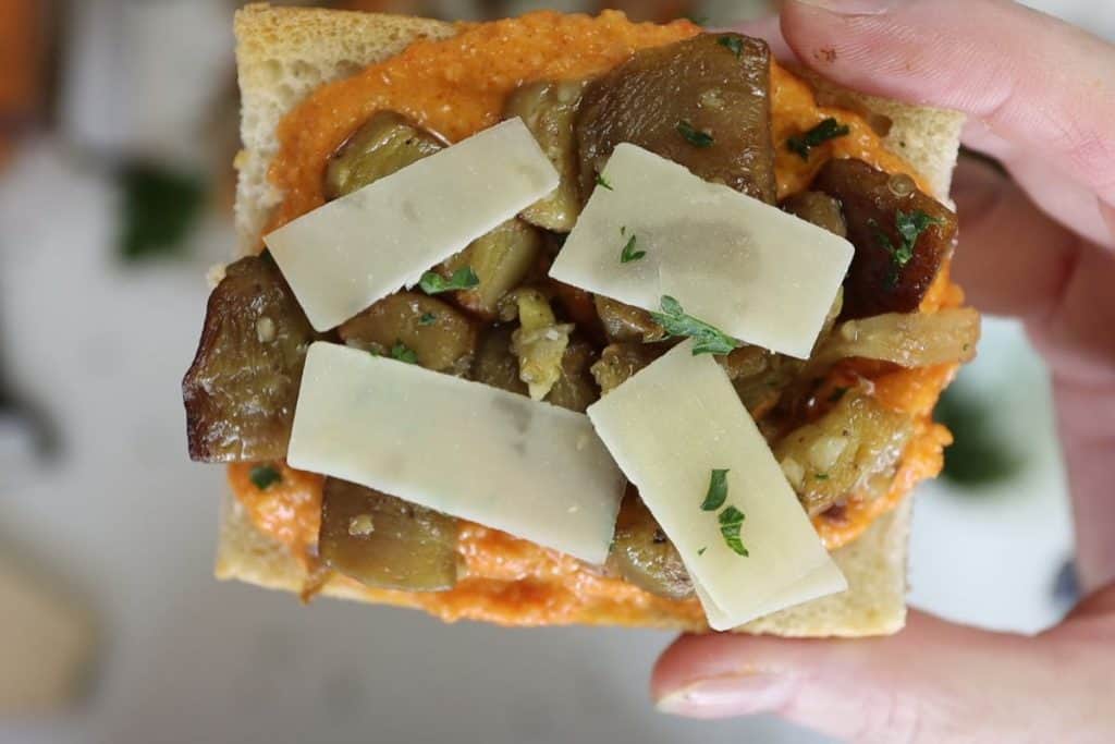 french bread pizza with romesco sauce: a close of look of one French bread pizza with with romesco sauce and eggplant and shaved parmesan cheese