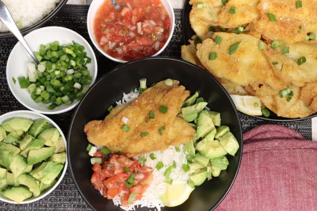McCormick Fish Fry Flounder: wide overhead view of one portion with more fish on a platter, avocado, pico de gallo and scallions