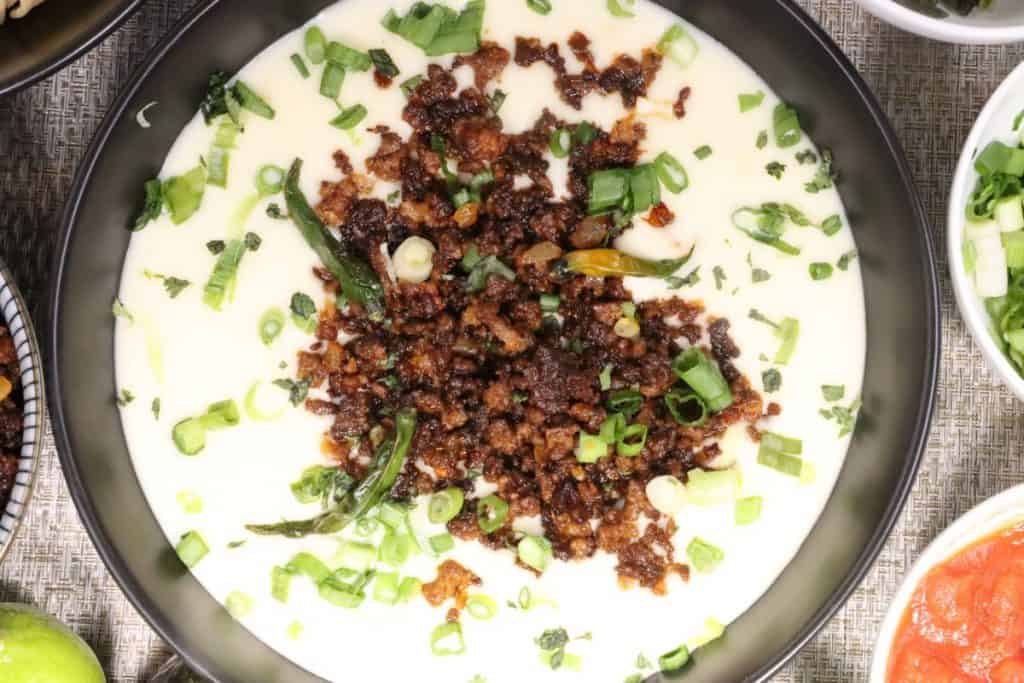 close up overhead view of super bowl white queso dip with crispy crumbled beef