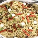 Pesto Pasta with Olives: overhead view of family-style platter of linguine with pesto, olives, shiitakes, artichokes, mozzarella, toasted pine nuts and sun dreid tomatoes