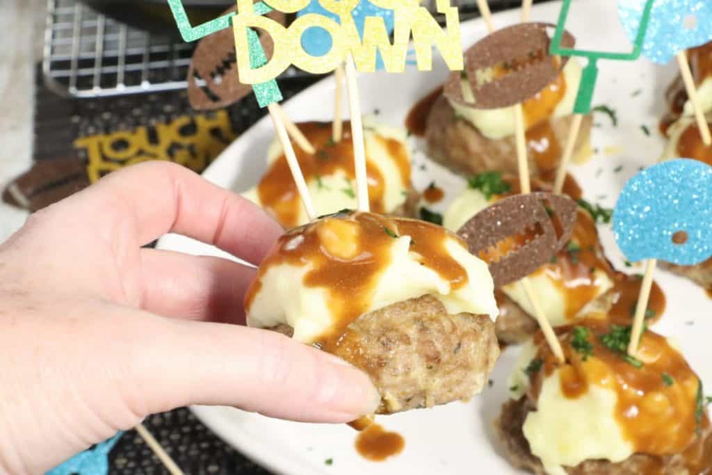 super bowl meatloaf bites with mashed potatoes and gravy holding in my hand so you can see the size
