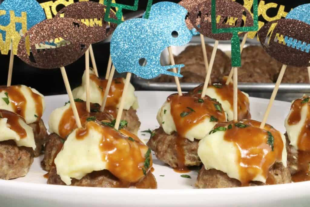 close up look at super bowl meatloaf bites with mashed potatoes and gravy on a platter