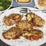 Stuffed Chicken Breast with Roasted Tomatoes, Goat Cheese and Leeks: overhead view of platter of chicken with broccoli on side and one portion in the right corner. Serve the extra cooked cheese mixture on the side too