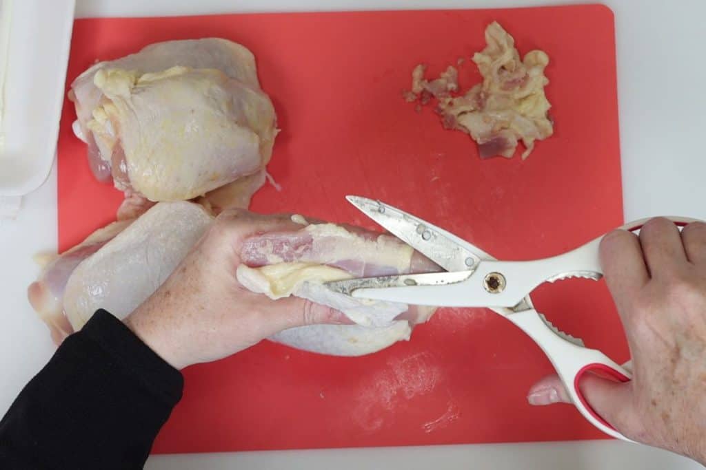 how to trim the fat from chicken thighs: under the top layer of skin is more hidden fat. Scissor skimming technique is useful here