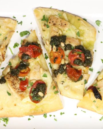Tasty Homemade Pizza Dough with Chicken, Pesto, Fontina & Tomatoes: four slices of both kinds of pizza on a platter
