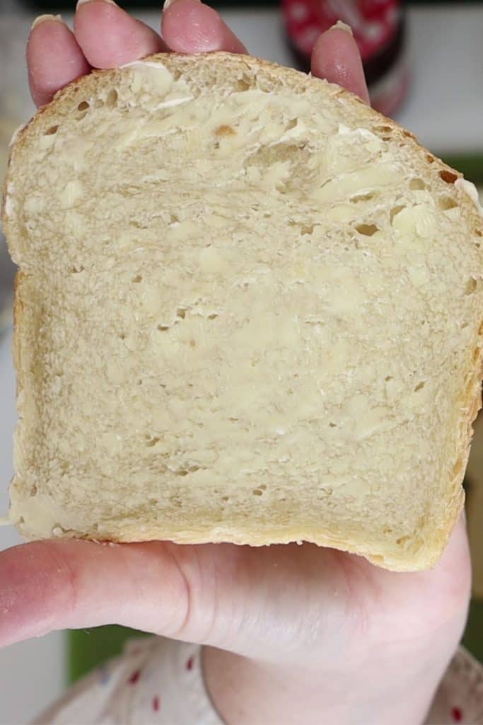 close up look of a lightly buttered slice of sourdough bread