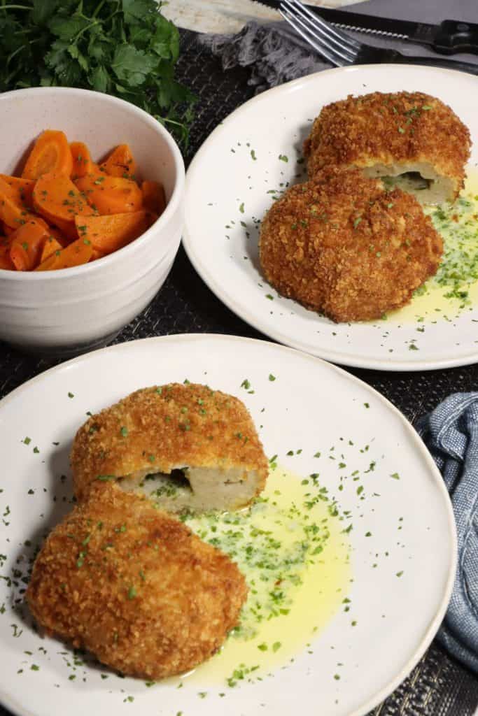 dinner for two ground chicken kiev: two plates of chicken kiev sitting in a pool of delicious parsley garlic butter