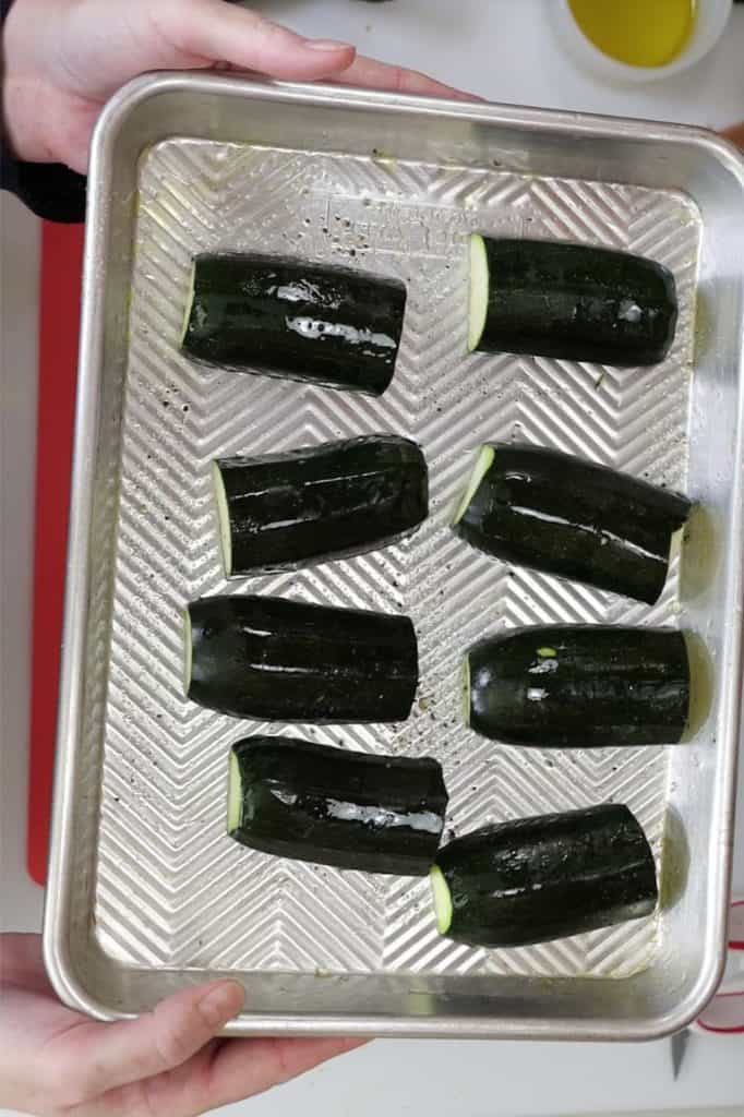 cut zucchini on a sheet pan with olive oil salt and pepper