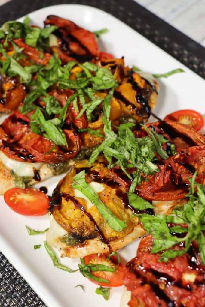 platter of chicken caprese with roasted tomatoes balsamic glaze and basil