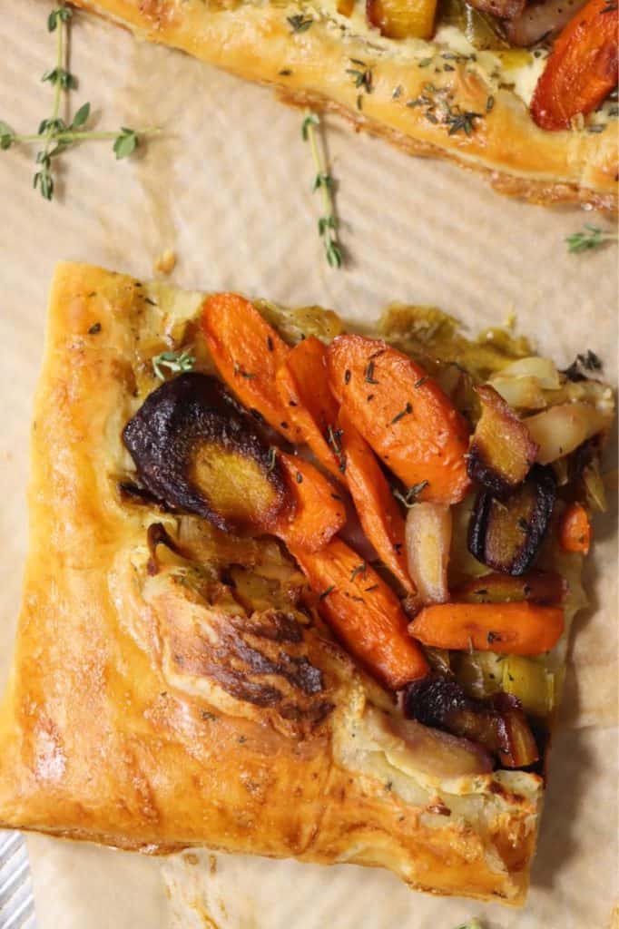 closer look at one slice of rainbow carrot tart on parchment paper