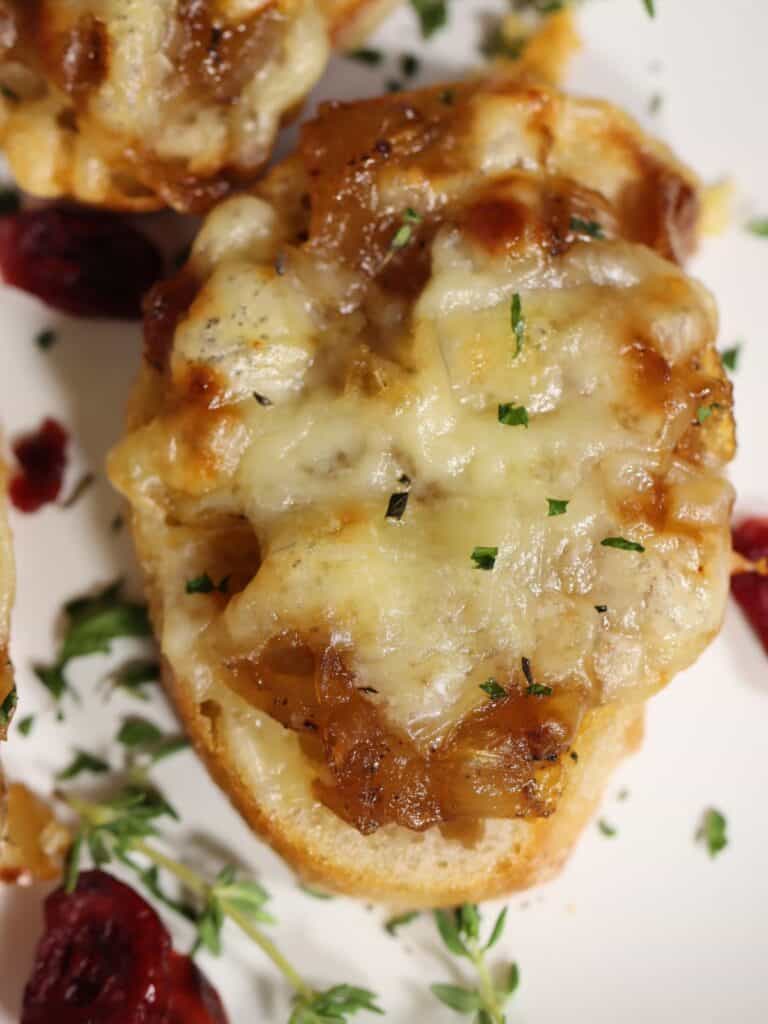 close up view of one french onion crostini on a serving platter