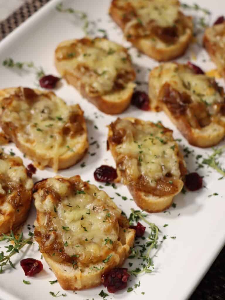 side view of crunchy french onion soup crostini on a serving tray