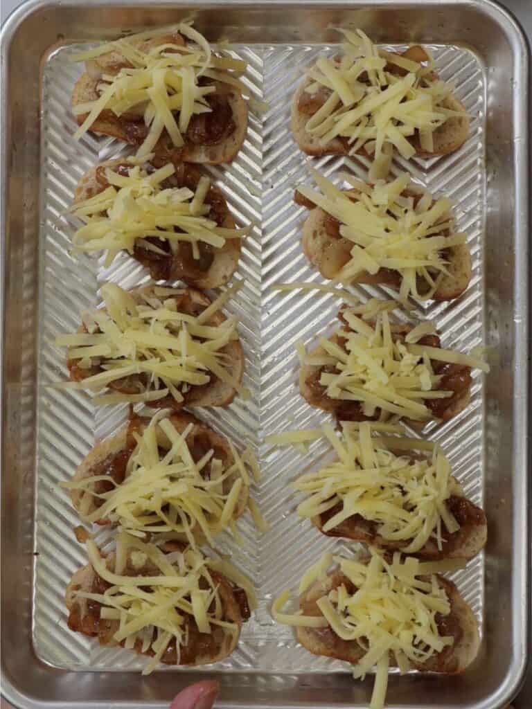 french onion crostini on a sheet pan ready to cook in the oven