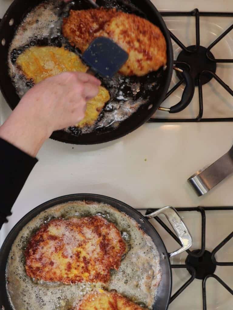 turning the cheddar chicken cutlets in pans