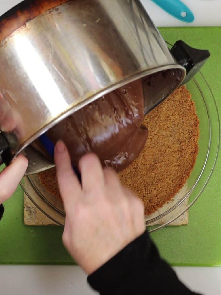 pouring the chocolate filling onto the cooled graham cracker crust