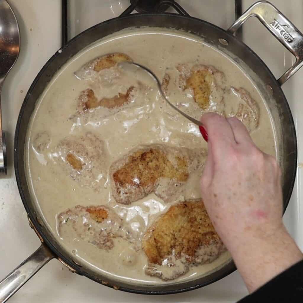 spooning sauce over the chicken cutlets for How to make easy and delicious creamy dijon chicken
