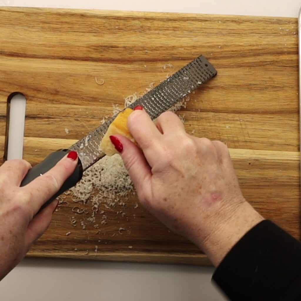 grating some fresh parmesan cheese for How to make easy and delicious creamy dijon chicken