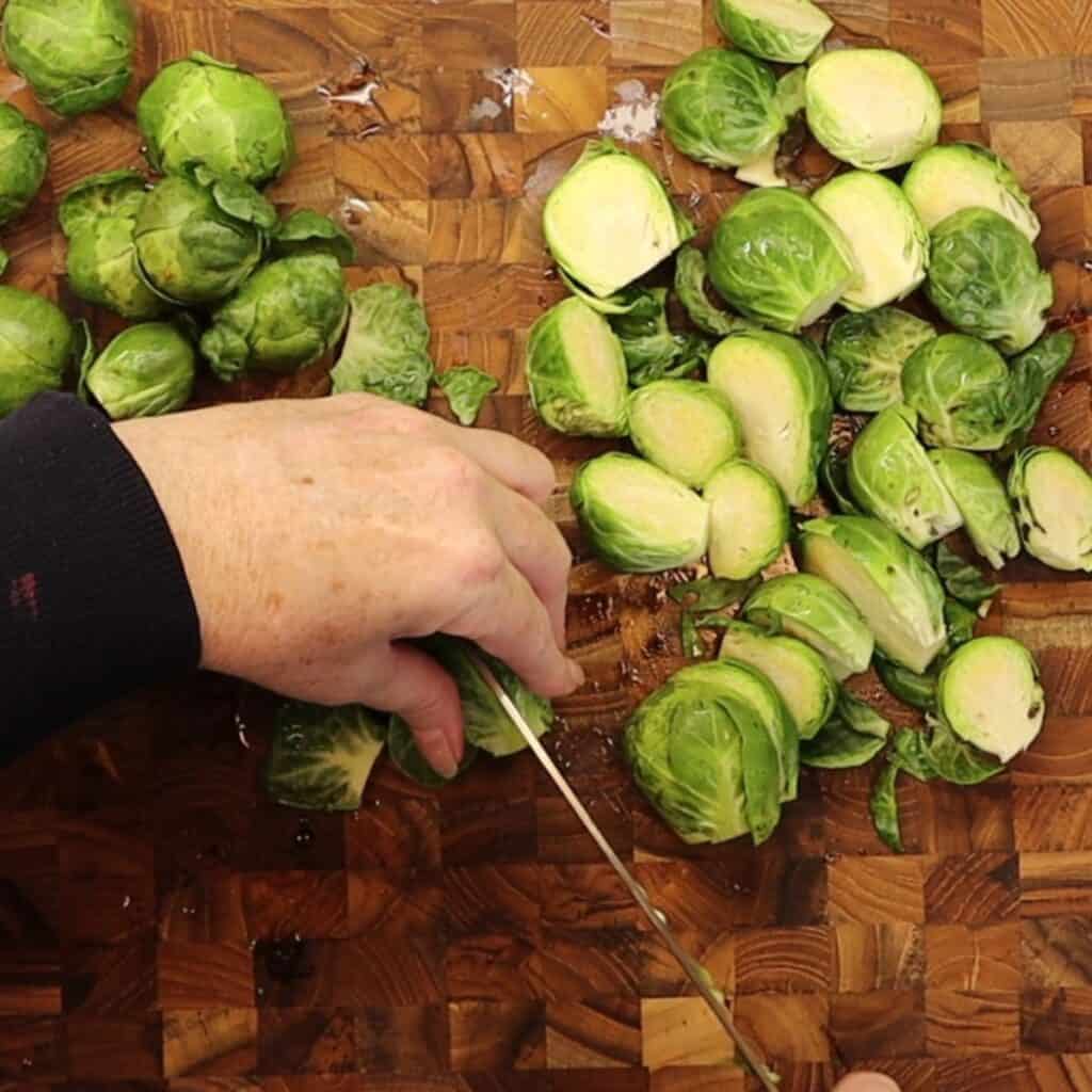 slicing the brussels sprouts in half before roasting