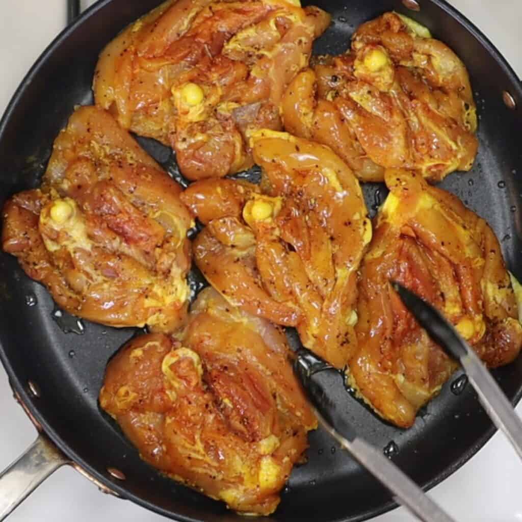 chicken thighs skin side down for crispy saffron chicken thighs with barberries and pigeon peas